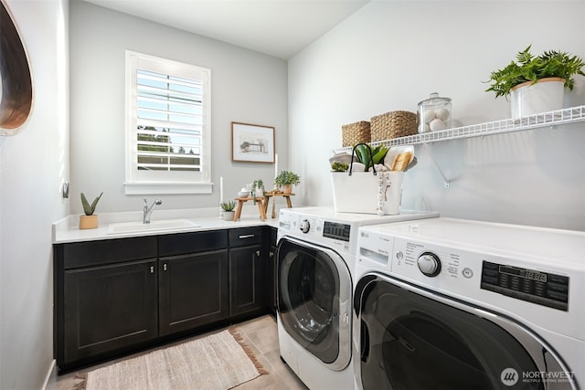 washroom with a sink, cabinet space, and washing machine and clothes dryer