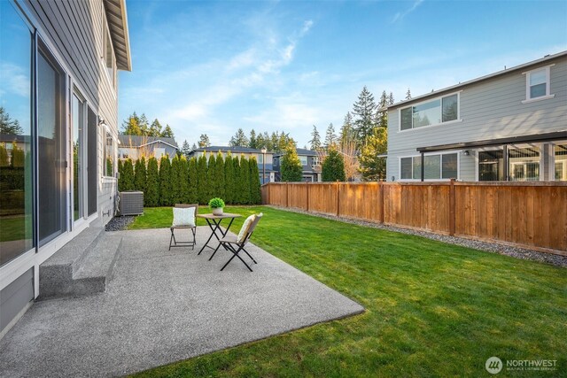 view of yard featuring a patio area, central AC, and fence