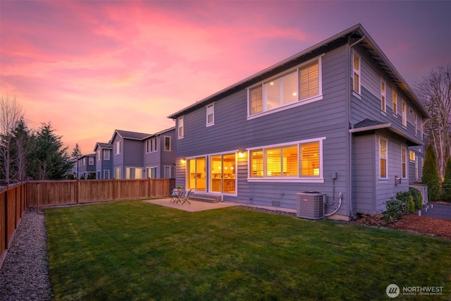 rear view of house with a lawn, a fenced backyard, crawl space, central AC unit, and a patio area