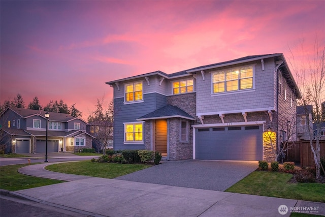 view of front of home with fence, concrete driveway, a front yard, a garage, and stone siding