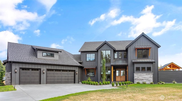 modern farmhouse with driveway, a shingled roof, a front lawn, a garage, and board and batten siding