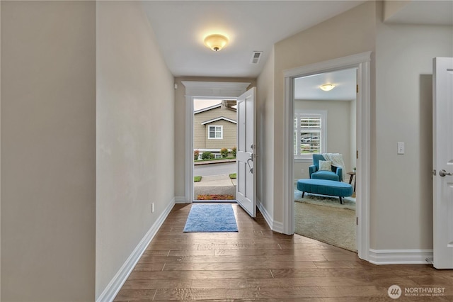 entryway featuring visible vents, baseboards, and wood finished floors