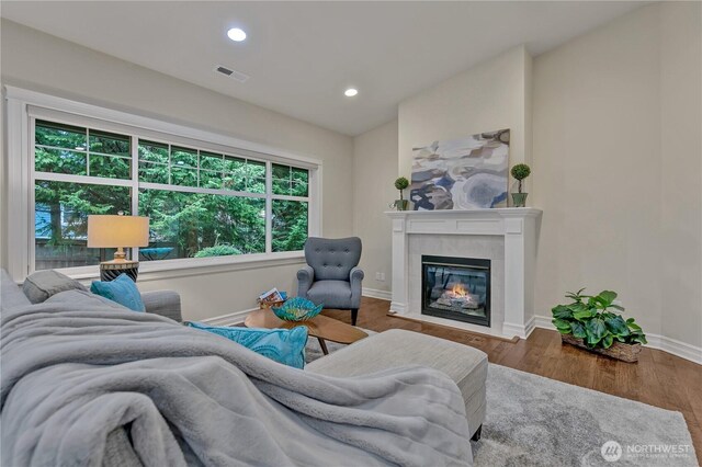 living room featuring lofted ceiling, wood finished floors, recessed lighting, a fireplace, and baseboards