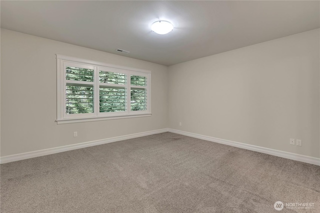 spare room featuring visible vents, baseboards, and carpet flooring