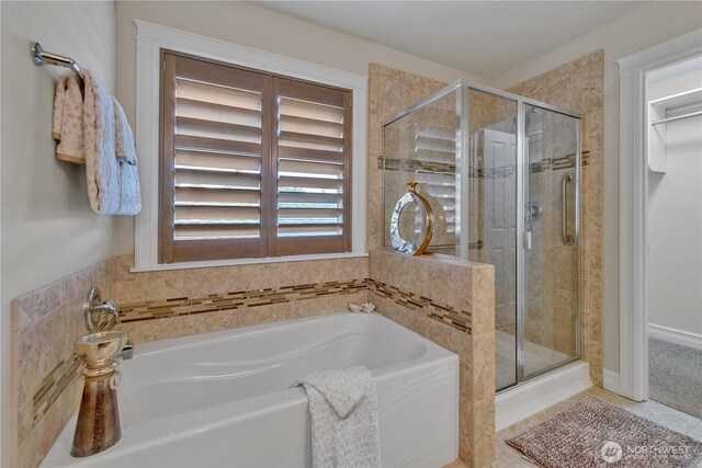 bathroom featuring a garden tub, a stall shower, and tile patterned floors