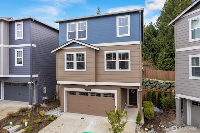 view of front facade featuring an attached garage, fence, and driveway