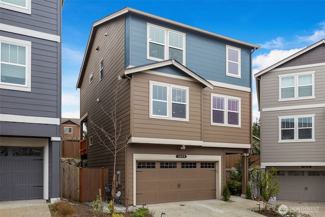 view of front of home featuring a garage, driveway, and fence