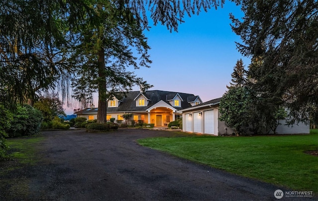 view of front of property featuring a garage, a front yard, and driveway