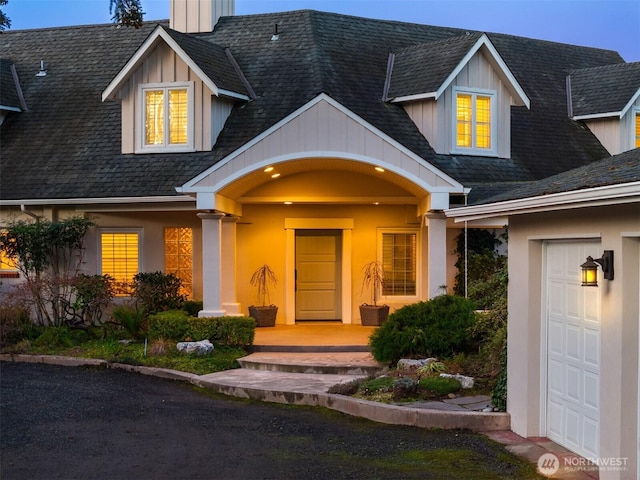 view of exterior entry featuring roof with shingles