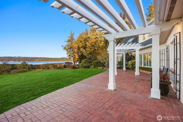 view of patio with a pergola and a water view