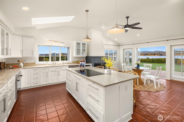 kitchen with oven, a center island, white cabinetry, glass insert cabinets, and black electric stovetop