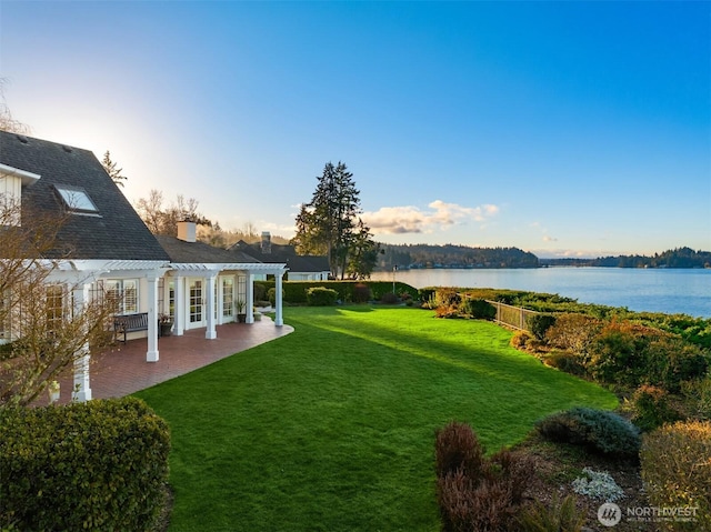 view of yard with a pergola, a patio, and a water view