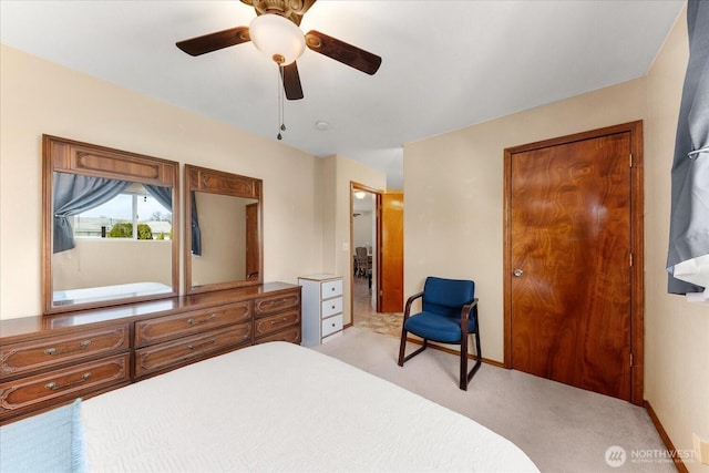 bedroom with light colored carpet, a ceiling fan, and baseboards