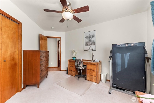 office space with light carpet and a ceiling fan