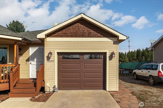 view of front facade with a garage, driveway, and a shingled roof