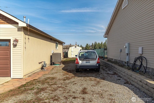 view of home's exterior with a storage shed, an outdoor structure, central air condition unit, and a garage