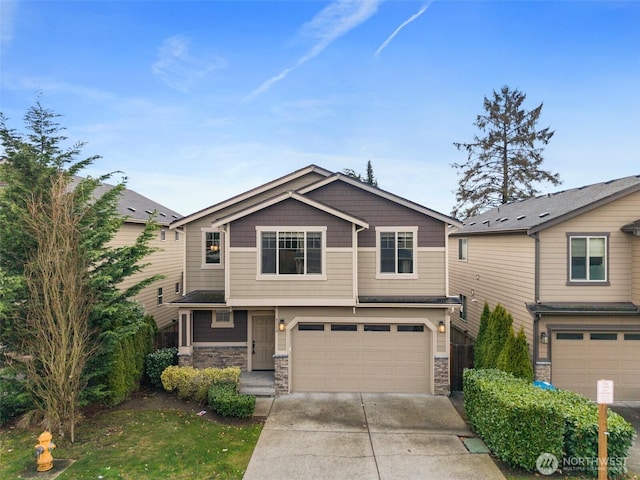 craftsman-style home with concrete driveway, a garage, and stone siding