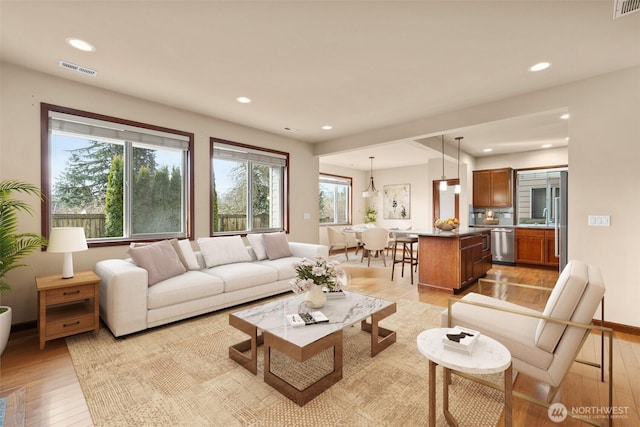 living room featuring visible vents, recessed lighting, and light wood-type flooring