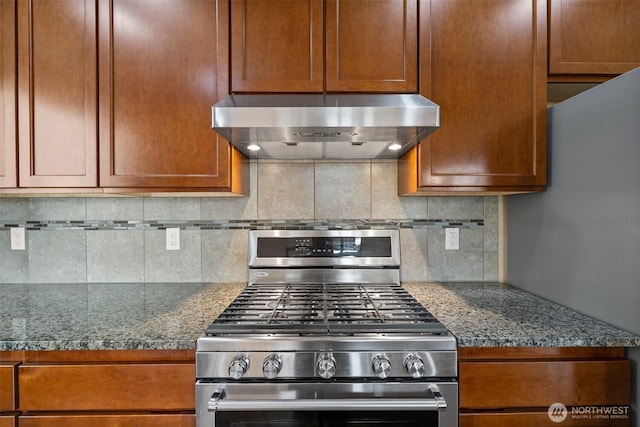 kitchen with backsplash, stainless steel range with gas stovetop, range hood, and dark countertops