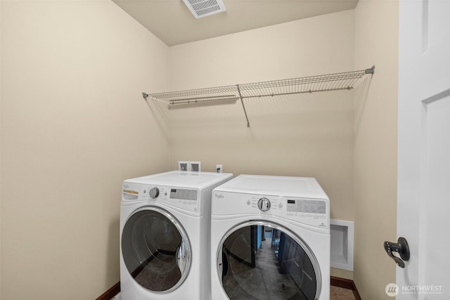 clothes washing area featuring laundry area, baseboards, visible vents, and washing machine and clothes dryer