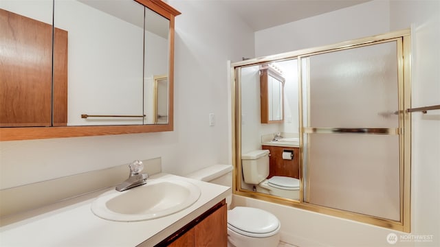 bathroom with vanity, toilet, and shower / bath combination with glass door