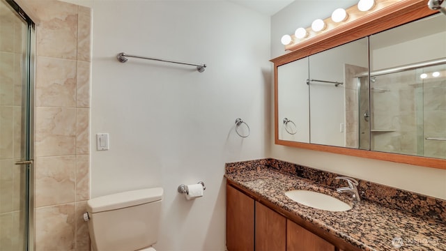 full bath featuring tiled shower, toilet, and vanity