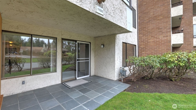 entrance to property with a patio area and stucco siding