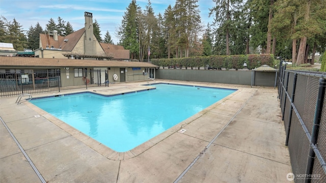 community pool featuring a patio area and fence