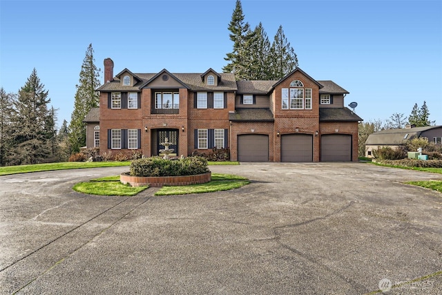 view of front of property with aphalt driveway, brick siding, and an attached garage