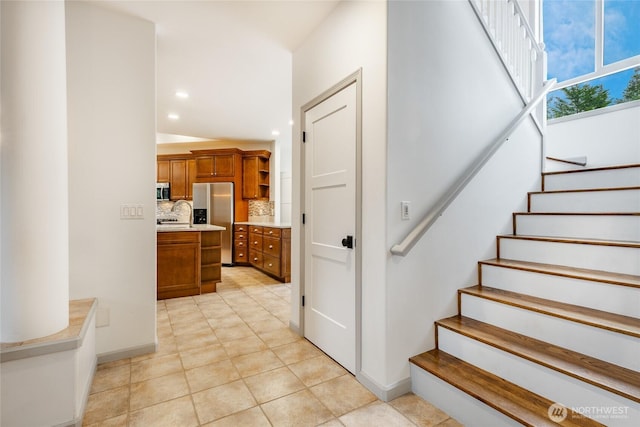 staircase with tile patterned floors, recessed lighting, and baseboards