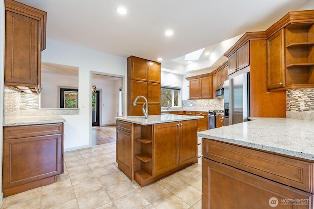 kitchen featuring open shelves, stainless steel appliances, brown cabinets, and a skylight