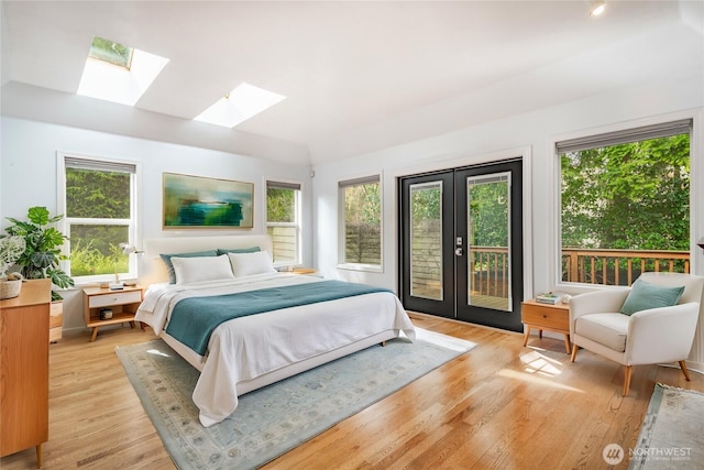 bedroom featuring french doors, multiple windows, light wood-style floors, and access to exterior