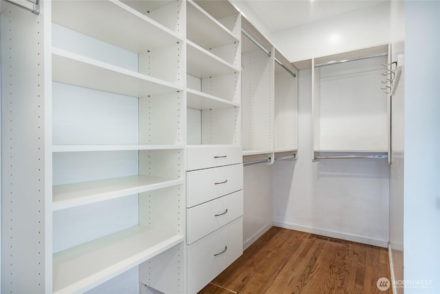 walk in closet with wood finished floors