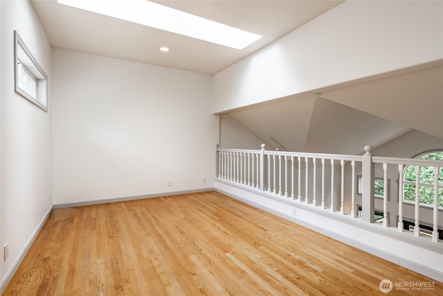 unfurnished room featuring recessed lighting, baseboards, wood finished floors, and a skylight
