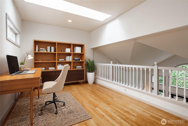 office area featuring a skylight, recessed lighting, and wood finished floors