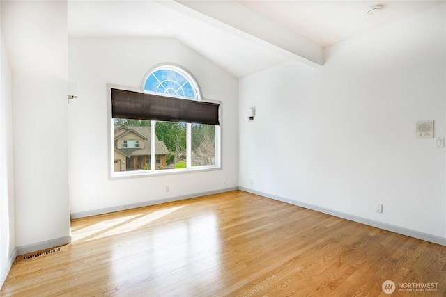 spare room with visible vents, vaulted ceiling with beams, and wood finished floors