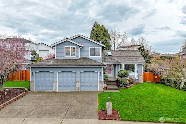 split level home with a front lawn, fence, and driveway