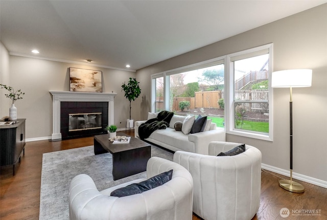 living room featuring recessed lighting, baseboards, dark wood-style flooring, and a tile fireplace