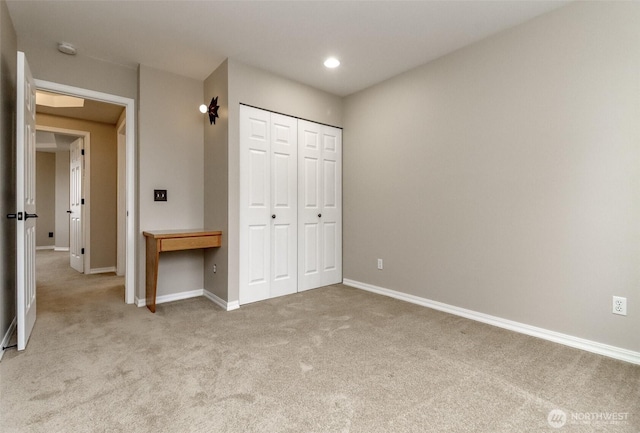 unfurnished bedroom with light carpet, recessed lighting, a closet, and baseboards