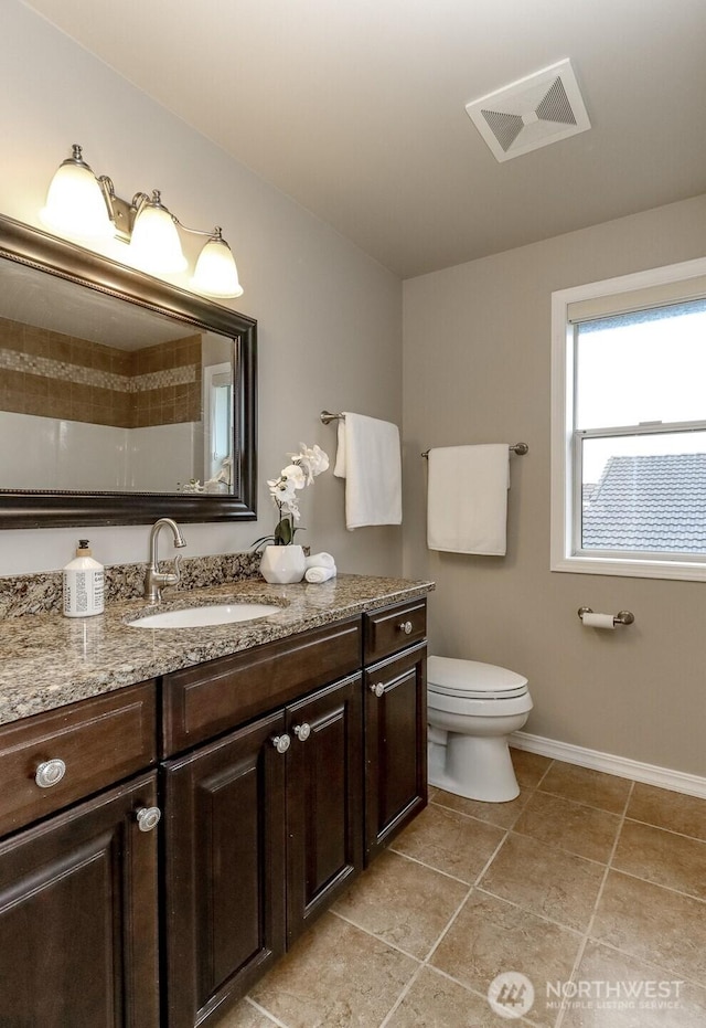 bathroom with vanity, baseboards, visible vents, tile patterned floors, and toilet