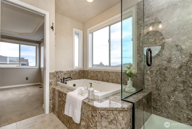 bathroom with a bath, a healthy amount of sunlight, and a stall shower