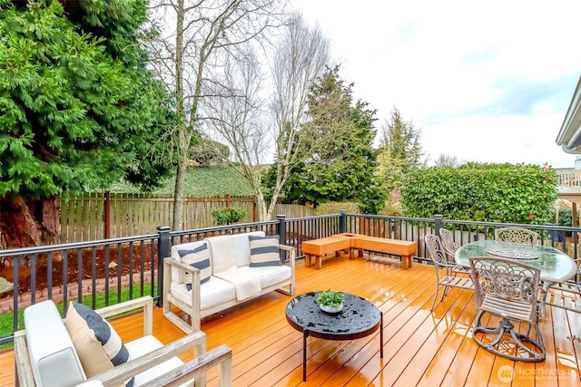 wooden terrace featuring an outdoor living space and a fenced backyard