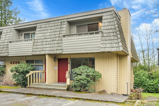 multi unit property with a balcony and mansard roof