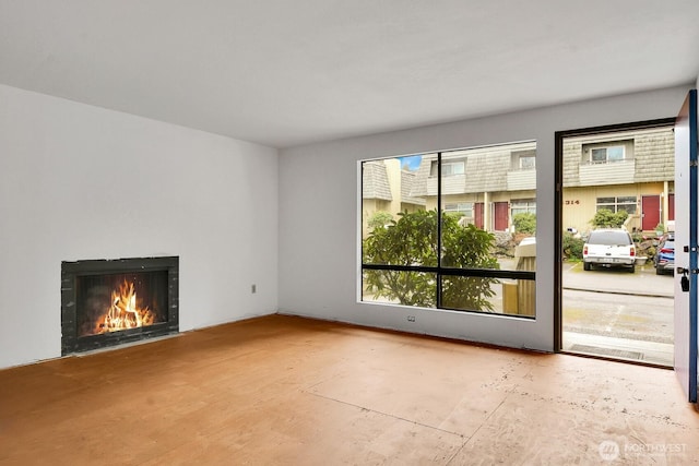 unfurnished living room featuring a fireplace with flush hearth