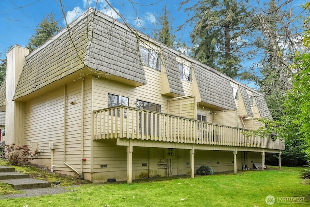 rear view of property with crawl space, mansard roof, a lawn, and a deck