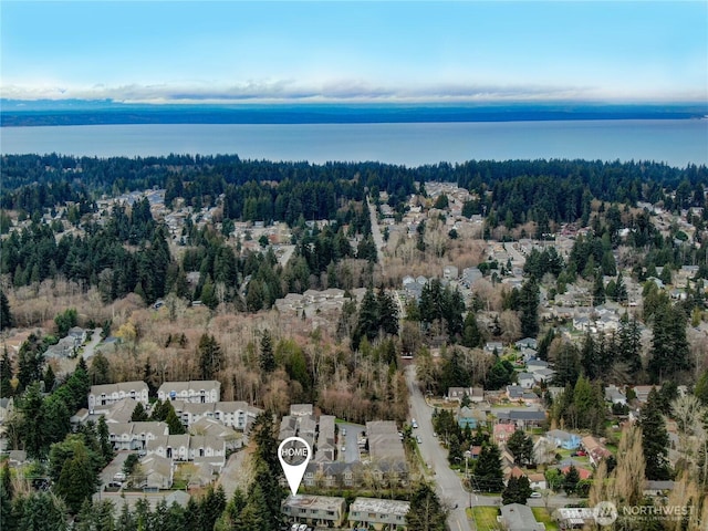 bird's eye view featuring a wooded view and a water view