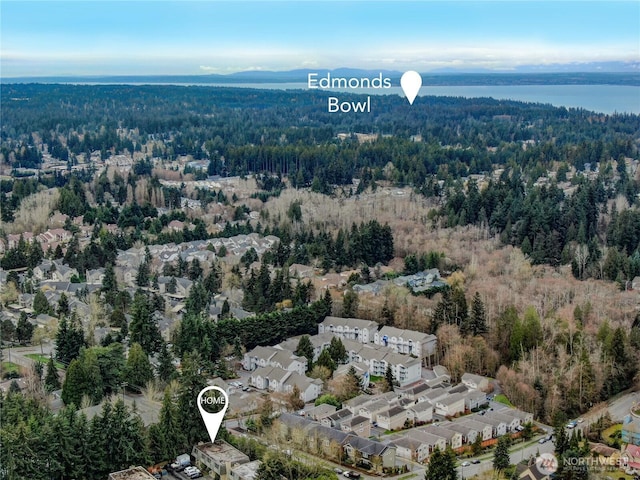 birds eye view of property featuring a forest view and a water view