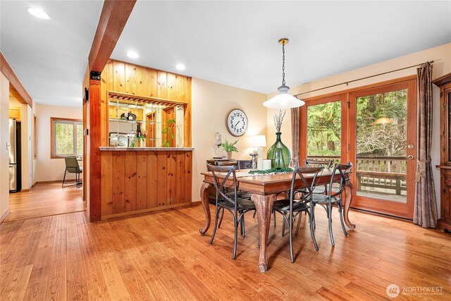 dining area featuring baseboards, recessed lighting, beamed ceiling, light wood-type flooring, and a dry bar