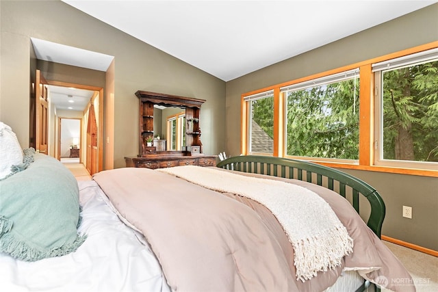 bedroom with baseboards, lofted ceiling, and carpet flooring