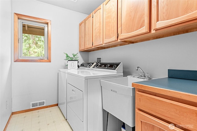 laundry room with washing machine and clothes dryer, visible vents, baseboards, light floors, and cabinet space